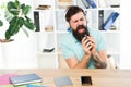 Office life rhythm. Regular office day. Man bearded guy headphones sit office listen music sing song. Worker with coffee