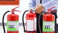 Office man checking the handle of the red fire extinguishers tank Royalty Free Stock Photo