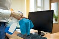 Man cleaning computer with disinfectant spray and microfiber cloth. Royalty Free Stock Photo