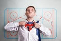 The office man opens a white shirt and shows the hockey sports form. Against the backdrop of the coaching scheme of halftime