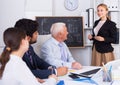 Office manager female is reading financial report to colleagues on meeting Royalty Free Stock Photo