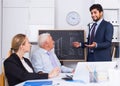 Office manager male is reading financial report to colleagues on meeting Royalty Free Stock Photo