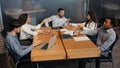 Office meeting briefing diverse staff members team workers colleagues managers sit at table in modern boardroom discuss