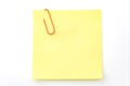 Office memo and reminder note concept with blank self adhesive yellow sticky note with paperclip isolated on white background with