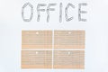 Office object. The word office, faded on a white background with metal stationery clips. The concept of office work Royalty Free Stock Photo