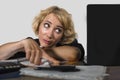 Office portrait of young sad and depressed business woman working lazy at laptop computer desk feeling bored and tired looking tho Royalty Free Stock Photo