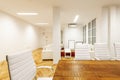 Office with raw wood conference table, white upholstered swivel chairs and matching sofas