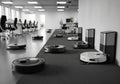 Office setting with multiple robotic vacuum cleaners operating and Royalty Free Stock Photo
