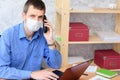 Office specialist in a medical mask works at a computer in the office