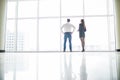 Office staff is discussing something by the window standing with their backs Royalty Free Stock Photo