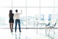 Office staff is discussing something by the window standing with their backs. Team work. Royalty Free Stock Photo