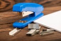 Office stapler, stapler staples and white paper on the table, close-up, selective focus Royalty Free Stock Photo