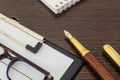 Office still life blank form, glasses and pen for drawing up report on brown wooden table Royalty Free Stock Photo