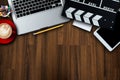 Office stuff with Movie clapper, laptop, smartphone, tablet, coffee cup, pen, notepad and documents on the wood table top view Royalty Free Stock Photo