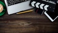 Office stuff with Movie clapper, laptop, smartphone, tablet, coffee cup, pen, notepad and documents on the wood table Royalty Free Stock Photo