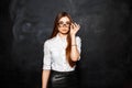 Office Stylish girl in white blouse and skirt corrects glasses o Royalty Free Stock Photo