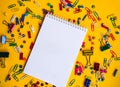 Office supplies of colored buttons and paper clips with empty note pad with copy space on yellow background Royalty Free Stock Photo