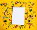 Office supplies of colored buttons and paper clips with empty note pad with copy space on yellow background Royalty Free Stock Photo