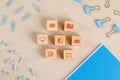 Office supplies concept with icons on wooden cubes, stationery set on paper background flat lay Royalty Free Stock Photo
