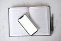 Top view of an open notebook with mobile phone Royalty Free Stock Photo