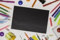 Office supplies in the form of a frame, space for text on a black school Board, white background, top view Royalty Free Stock Photo