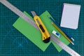 Office supplies on green cutting mat board Royalty Free Stock Photo