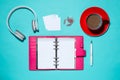 Office supplies. Top view on opened notebook, pen, headphone and Royalty Free Stock Photo