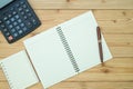 Office supplies or office work essential tools items on wooden desk in workplace, pen with notebook and calculator, top view Royalty Free Stock Photo