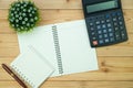 Office supplies or office work essential tools items on wooden desk in workplace, pen with notebook and calculator, top view Royalty Free Stock Photo