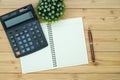 Office supplies or office work essential tools items on wooden desk in workplace, pen with notebook and calculator, top view Royalty Free Stock Photo