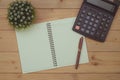 Office supplies or office work essential tools items on wooden desk in workplace, pen with notebook and calculator, top view Royalty Free Stock Photo