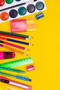 Office supplies on a yellow background. Various school supplies on a bright yellow background. Text frame with office supplies.