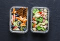 Office sweet and savory food lunch box. Pasta, tuna, spinach, avocado salad and fruit lunch box on dark