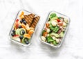 Office sweet and savory food lunch box. Pasta, tuna, spinach, avocado salad and fruit, peanut butter sandwiches lunch box on light