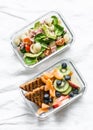 Office sweet and savory food lunch box. Pasta, tuna, spinach, avocado salad and fruit, peanut butter sandwiches lunch box on light