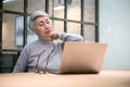 Mature asian business woman wears glasses using laptop computer sit at workplace desk Royalty Free Stock Photo