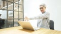 Mature asian business woman wears glasses using laptop computer sit at workplace desk Royalty Free Stock Photo