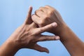 Office syndrome concept. Ring finger is massaged and stretched after working. Close up shot isolate on blue background. Backhand