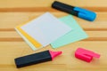 Office table with accessories: colorful sheets of paper, marker of blue and pink, Pink marker is open.