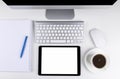 Office table with computer, wireless computer keyboard and mouse, cup of coffee, tablet computer.copy space notebook. empty screen Royalty Free Stock Photo