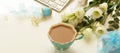 Office table desk with computer, beautiful bouquet white flowers, cup of cocoa and gift Royalty Free Stock Photo