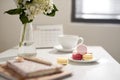 Office table desk. Feminine desk workspace frame with calendar, diary, hortensia bouquet, macaron and coffee on white background.