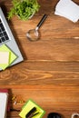 Office table desk with set of colorful supplies, white blank note pad, cup, pen, pc, crumpled paper, flower on wooden Royalty Free Stock Photo