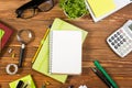 Office table desk with set of colorful supplies, white blank note pad, cup, pen, pc, crumpled paper, flower on wooden Royalty Free Stock Photo