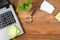 Office table desk with set of colorful supplies, white blank note pad, cup, pen, pc, crumpled paper, flower on wooden Royalty Free Stock Photo