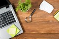 Office table desk with set of colorful supplies, white blank note pad, cup, pen, pc, crumpled paper, flower on wooden Royalty Free Stock Photo