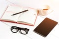 Office table desk with set of supplies, white blank notepad, cup, pen, tablet, glasses on white background. Top view Royalty Free Stock Photo