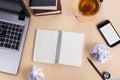 Office table desk with supplies, white blank note pad, cup, pen, pc, crumpled paper, flower on wooden background. Top