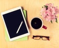 Office table with digital tablet, reading glasses and cup of coffee. View from above