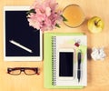 Office table with digital tablet, smartphone, reading glasses and healthy breakfast. View from above